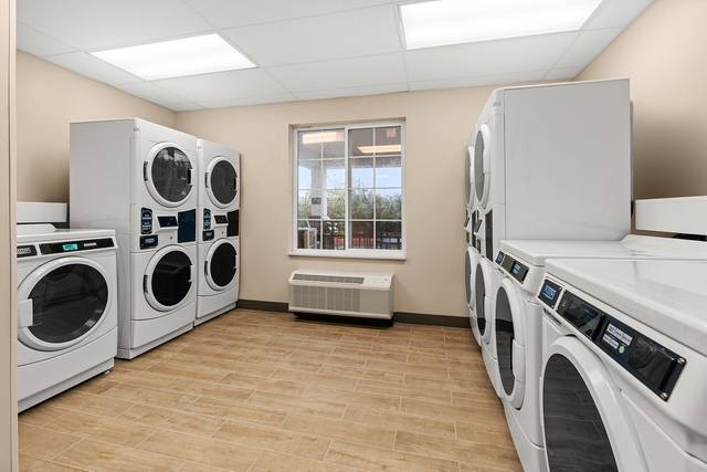 Self service laundry room with LED tube lights and folding station for guest convenience