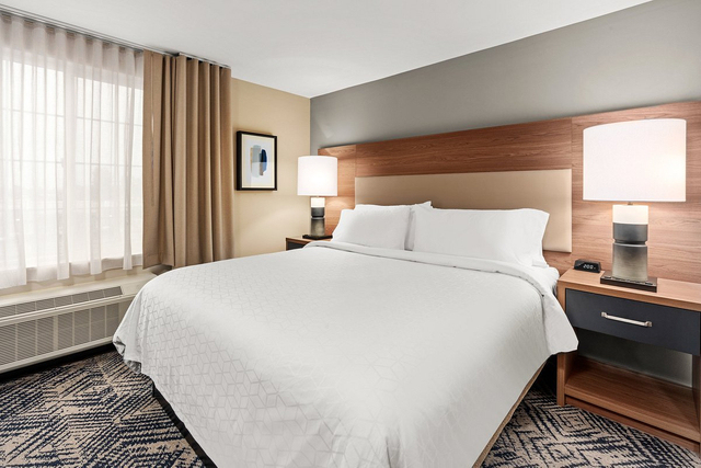Comfortable guest room with LED bedside lamps and energy saving ceiling light fixtures
