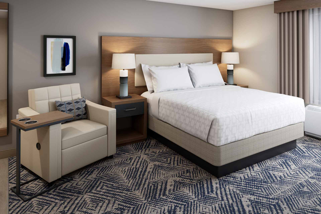 Deluxe king suite bedroom featuring LED reading lights and USB charging bedside tables
