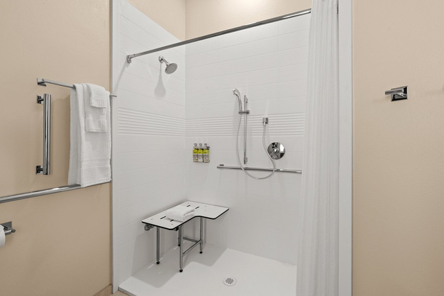 Accessible guest bathroom featuring LED vanity lights with motion sensor technology