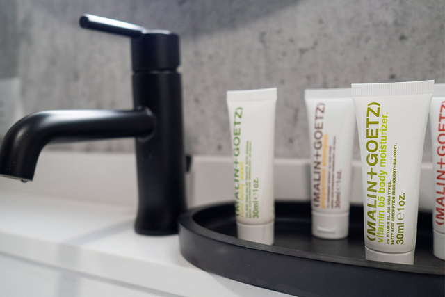 Malin Goetz hotel bathroom amenities display with LED vanity and mirror lighting