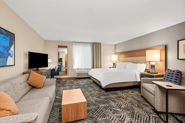 Extended stay suite living room with LED floor lamps and dimmable ambient lighting