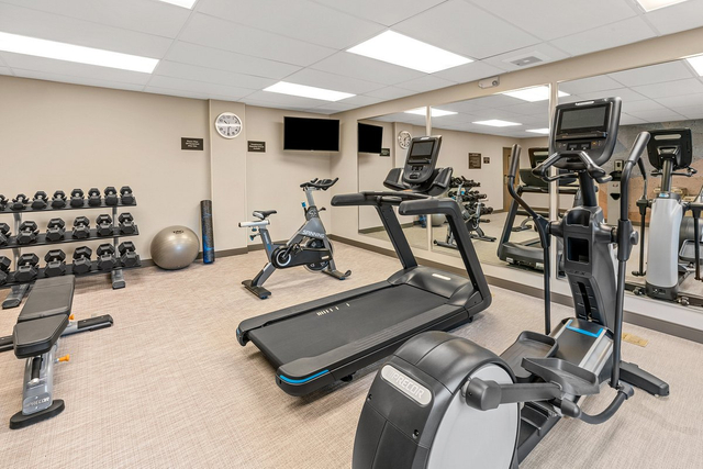 Hotel fitness center equipped with LED high bay lights and modern cardio equipment