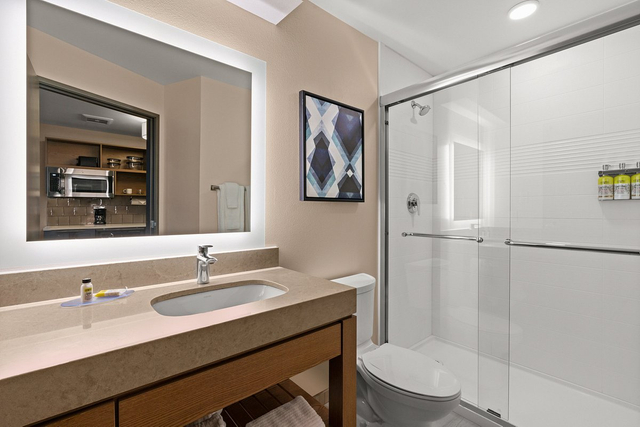 Luxury king suite bathroom with LED mirror lights and contemporary shower enclosure
