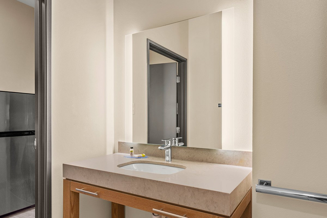ADA compliant guest bathroom featuring barrier free LED lighting and accessible fixtures